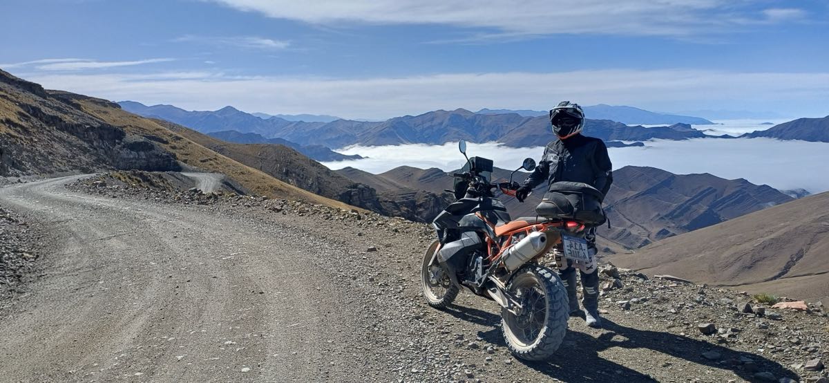 Motociclista en una ruta de montaña sobre las nubes en Salta y Jujuy